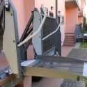Outdoor wheelchair platform lift raised to landing height at a home entrance door