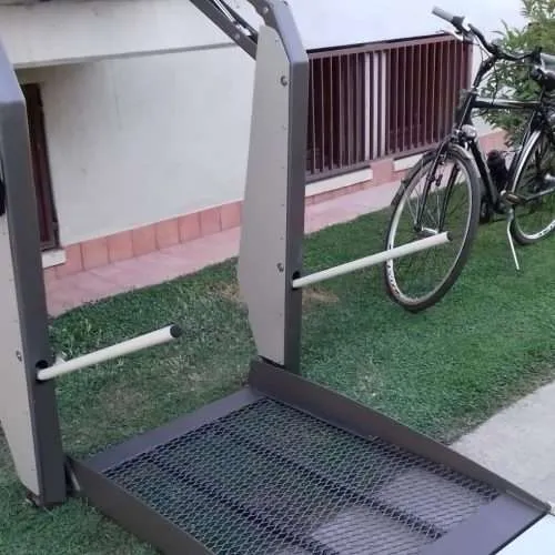 Open platform of a wheelchair lift with non-slip mesh surface and fold-up access ramp Open platform of a wheelchair lift with non-slip mesh surface and fold-up access ramp