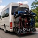 Disability transport van driving with rear-mounted walker carrier fully loaded with mobility walkers.