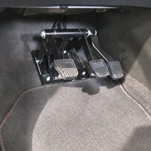 Three pedals dual control driving instructor system installed in manual vehicle footwell with brake, accelerator and clutch pedals