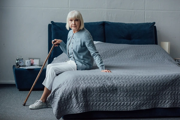 Old woman sitting on bed
