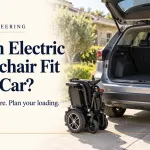 Folded electric wheelchair beside a silver SUV with its boot open.